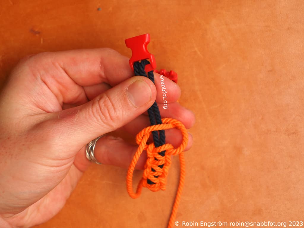 Två snören fästa i ett spänne