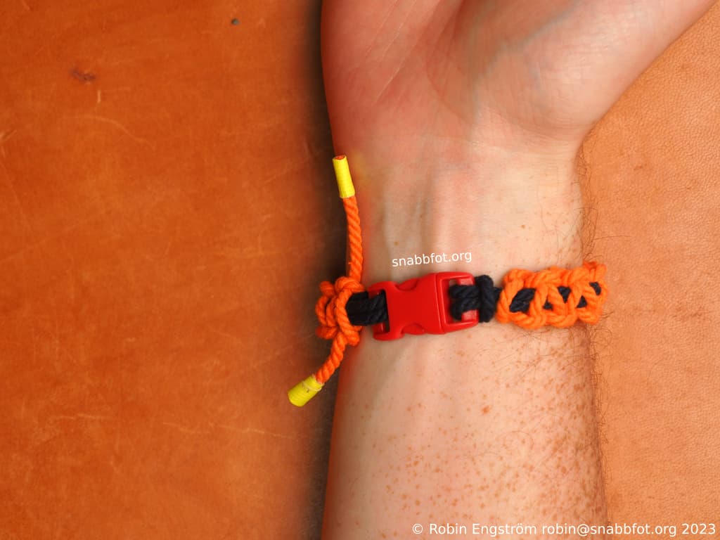 Två snören fästa i ett spänne