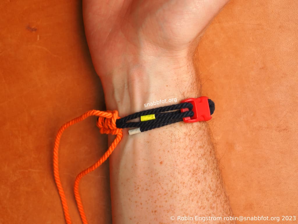 Två snören fästa i ett spänne